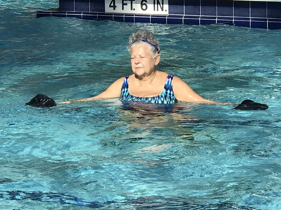 Older adult performing controlled upright resistance movement in chest-deep water