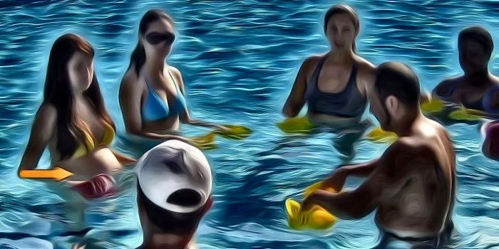 Pregnant client participating in group aquatic fitness class