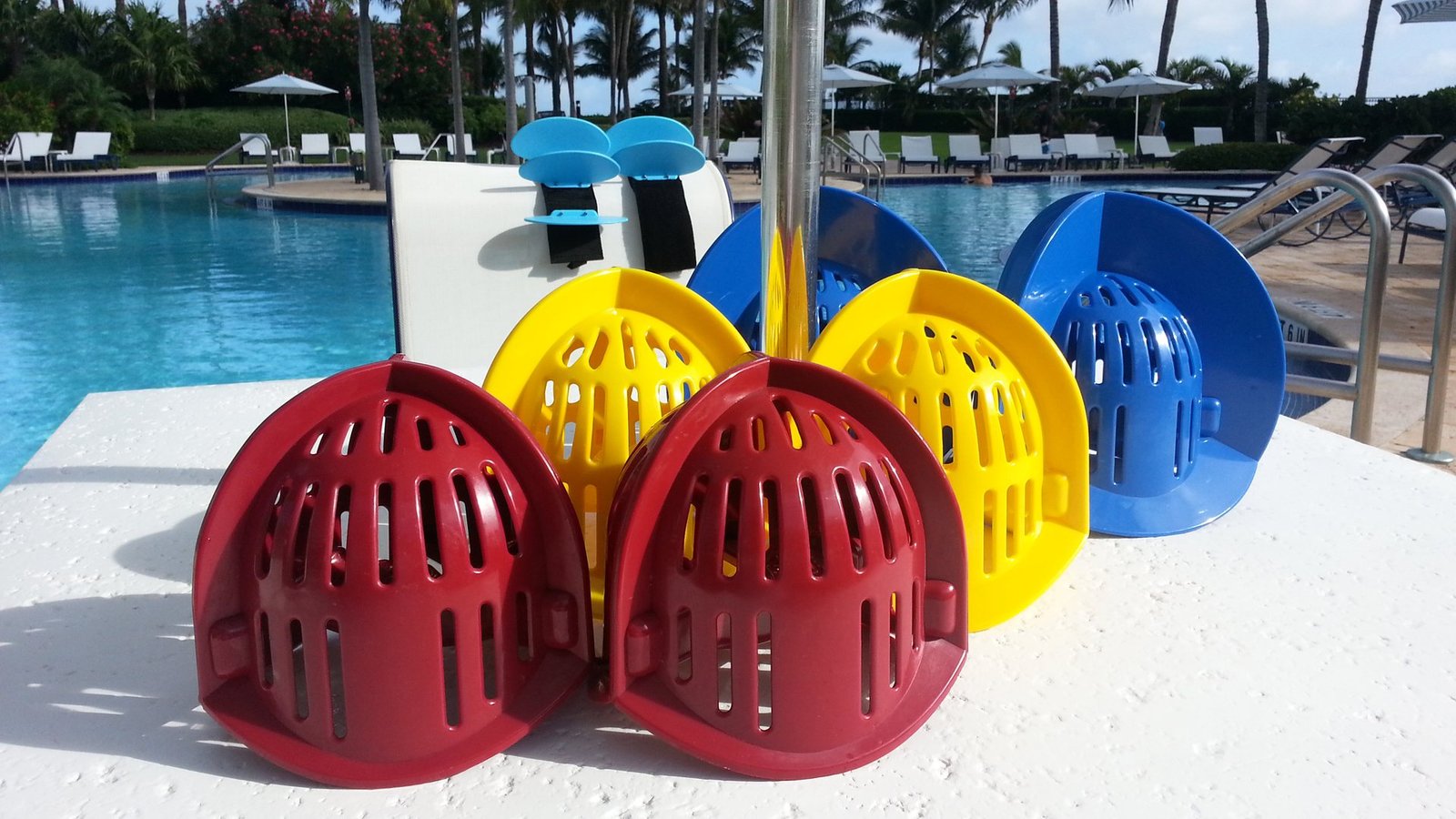 Several sizes of colorful aquatic resistance equipment arranged beside a South Beach pool.