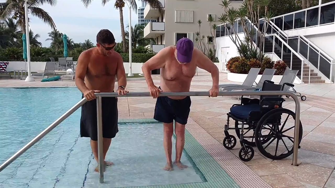 AquaFit Sports hydrotherapy — one-on-one support entering the pool for water-based recovery