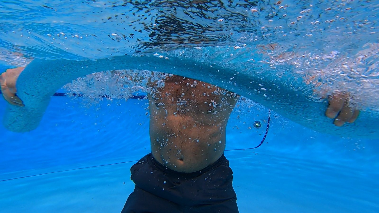Underwater view of upright aquatic resistance training with a pool noodle